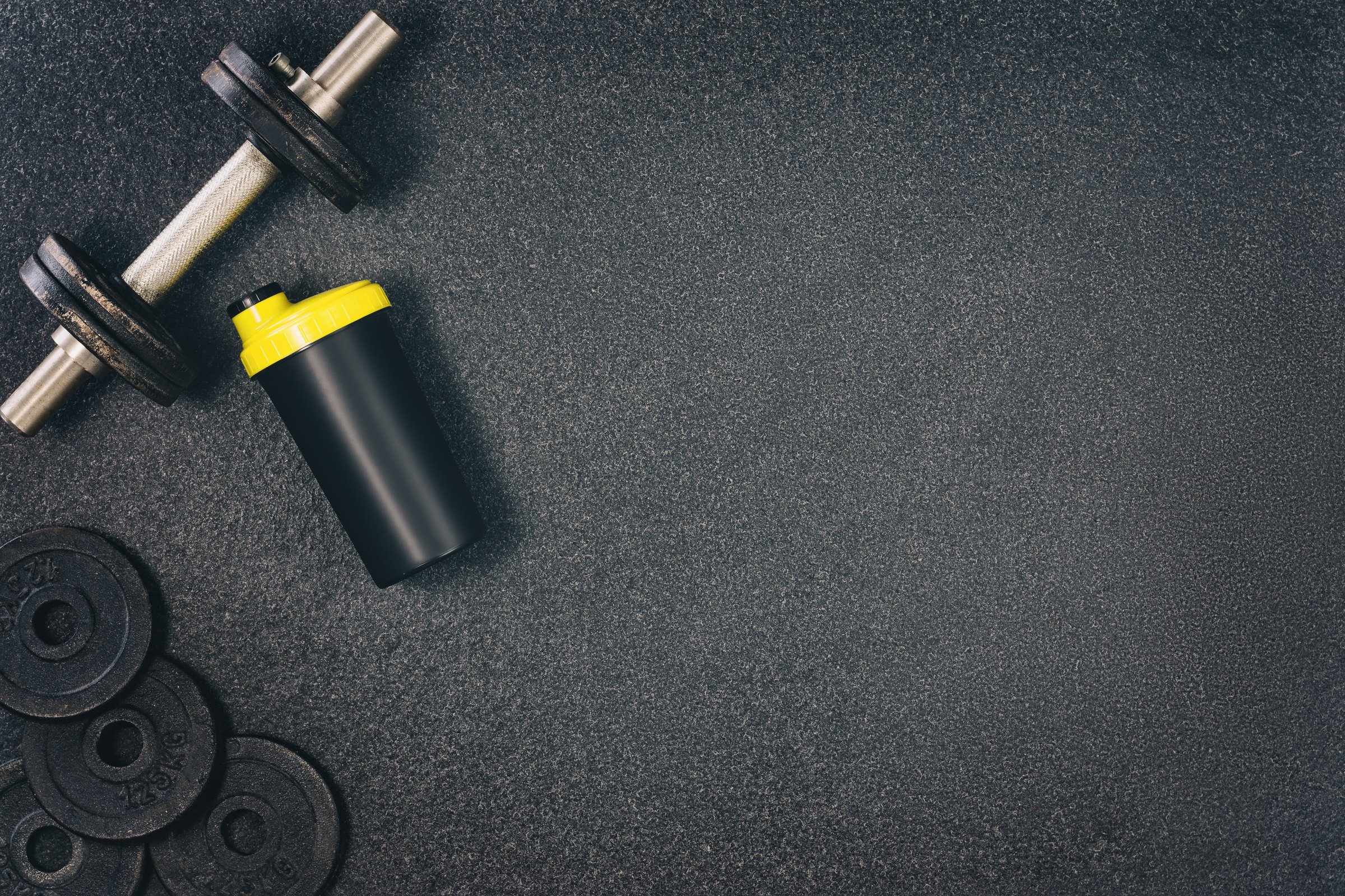 Fitness or bodybuilding background. Dumbbells on gym floor, top view